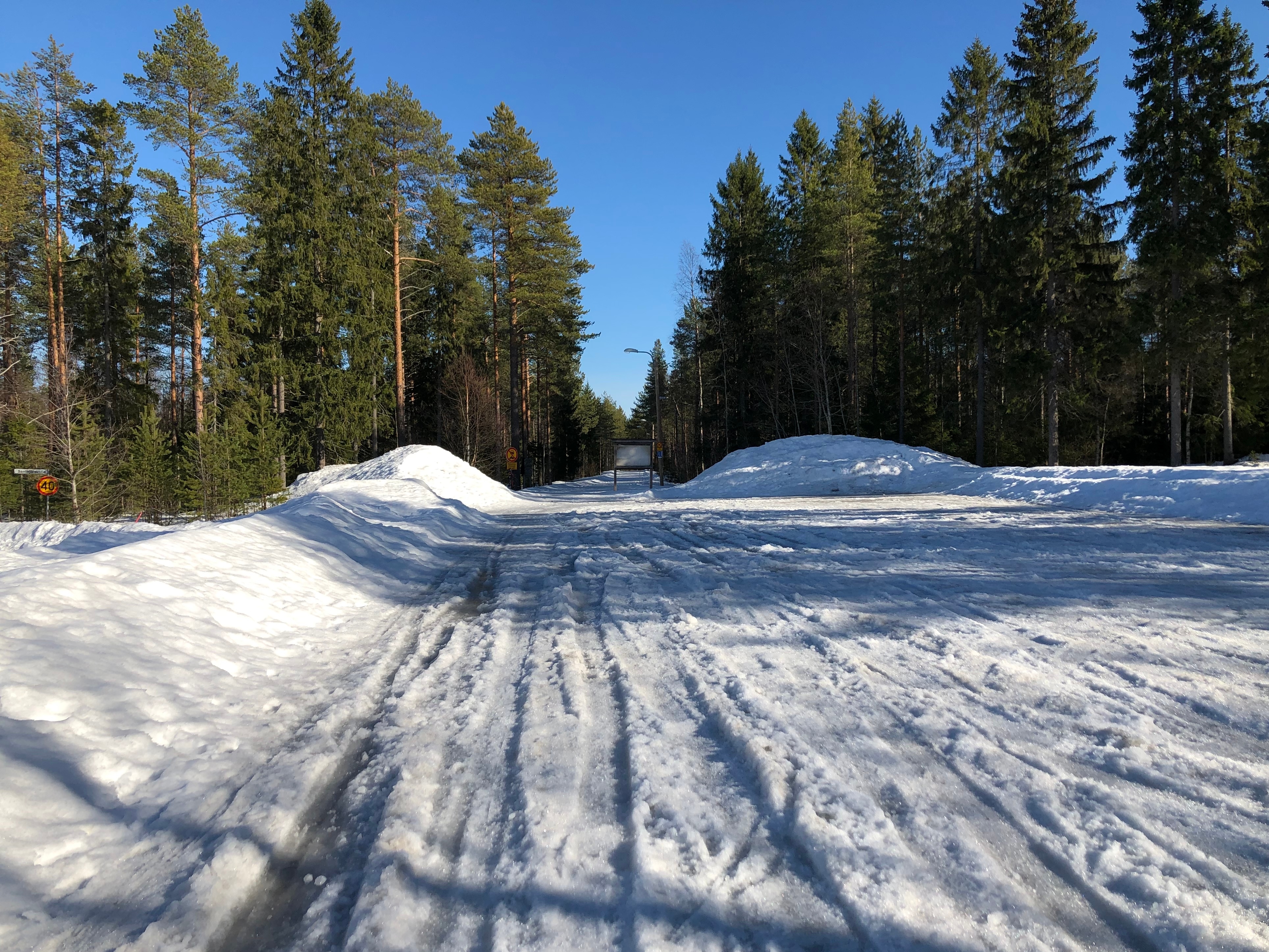 Herukka-Ahvenoja -kuntoradan Herukan-pää. Rata on lumen peitossa. Etualalla pysäköintialue, lumen peitossa sekin.