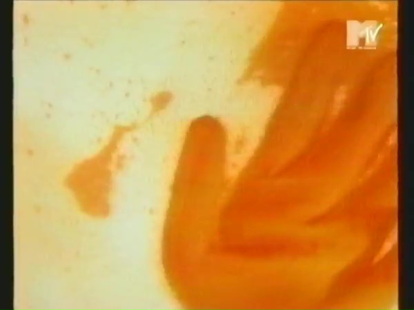 Kuvakaappaus videosta: oranssinpunainen vasen kämmen oikealla. Taustalla keltaista, jossa oransseja laikkuja. Oikeassa yläkulmassa MTV:n (Music Television) logo (1990-luvulta).